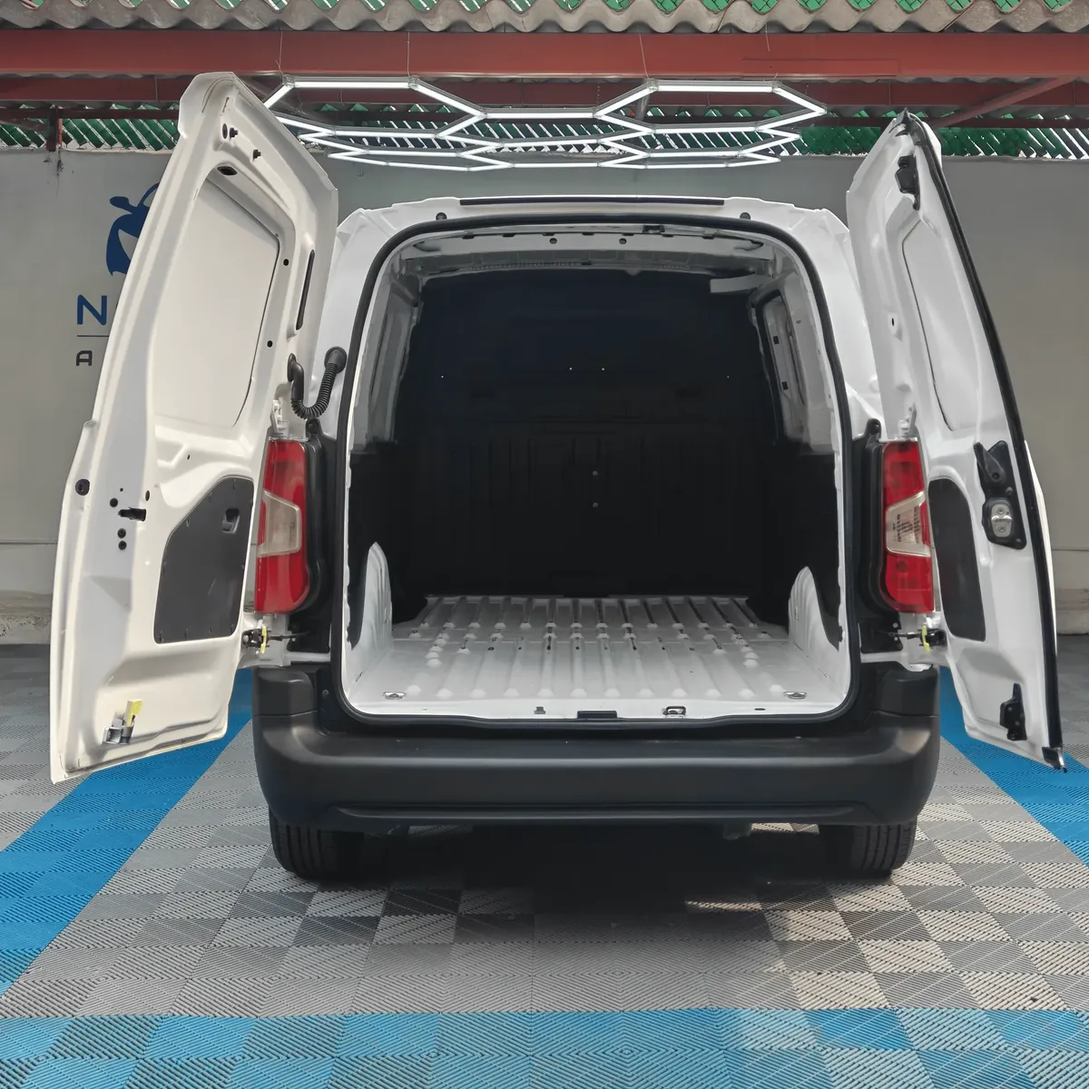 Camioneta de carga comercial Peugeot Partner 1.6 HDi Maxi transmisión manual año 2021 seminueva en color blanco, vista exterior trasera centrada con las puertas batientes abiertas mostrando el amplio compartimento de carga posterior en Namacar Automotriz.