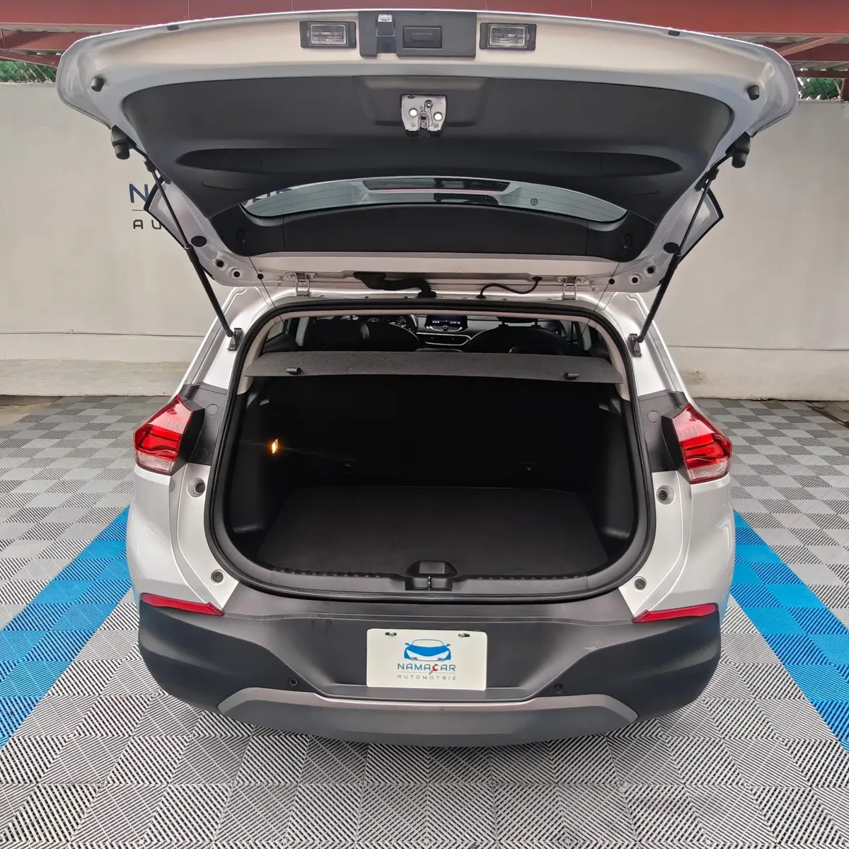 Camioneta SUV urbana Chevrolet Tracker 1.2 Premier Turbo transmisión automática año 2023 seminueva en color plata, vista exterior trasera centrada con la cajuela abierta mostrando el amplio espacio del maletero en Namacar Automotriz.