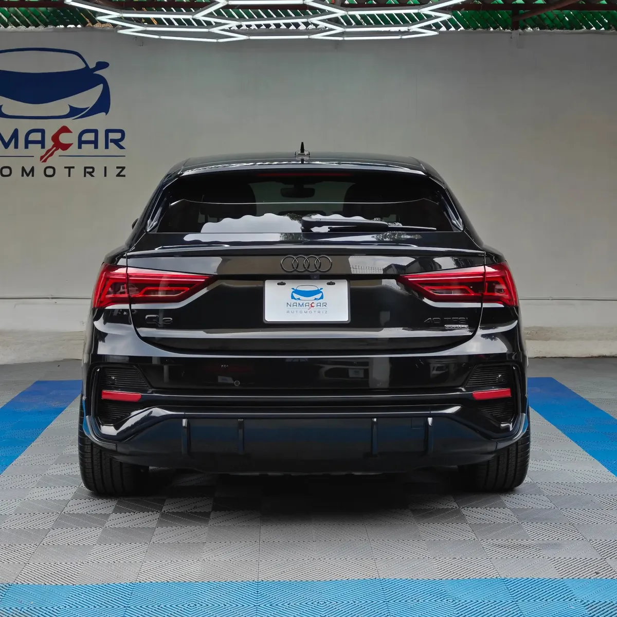 Camioneta SUV coupé de lujo Audi Q3 Sportback 2.0 S Line 180 Hp transmisión DSG automática año 2022 seminueva en color negro, vista exterior trasera directa y centrada a nivel de vista exhibida en Namacar Automotriz.