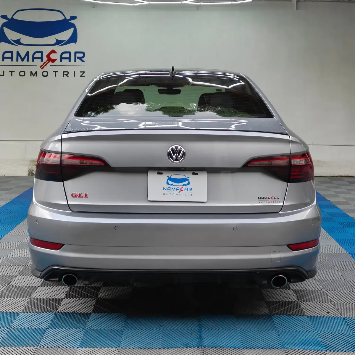 Auto sedán deportivo Volkswagen Jetta 2.0 GLI DSG automático año 2021 seminuevo en color gris plata, vista exterior trasera directa y completa exhibido en Namacar Automotriz.