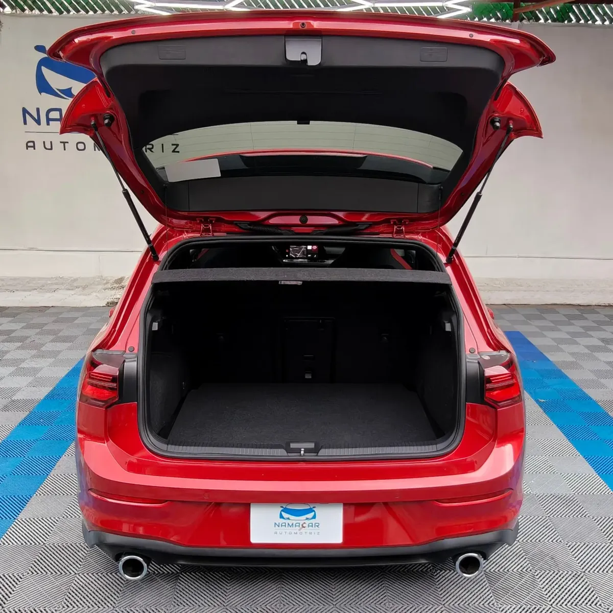 Hatchback deportivo Volkswagen Golf GTI 2.0 L de 241 HP automático DSG7 año 2024 seminuevo en color rojo brillante, vista exterior trasera centrada con el portón de la cajuela abierto mostrando el área de carga posterior exhibido en Namacar Automotriz.