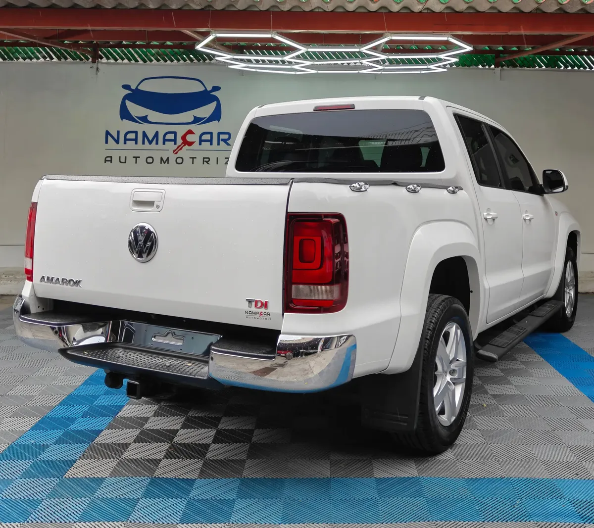 Camioneta pickup Volkswagen Amarok 2.0 Highline 4Motion automática año 2018 seminueva en color blanco, vista exterior trasera en ángulo de tres cuartos derecha exhibida en Namacar Automotriz.