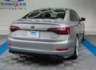Auto sedán deportivo Volkswagen Jetta 2.0 GLI DSG automático año 2021 seminuevo en color gris plata, vista exterior trasera en ángulo de tres cuartos derecha exhibido en Namacar Automotriz.