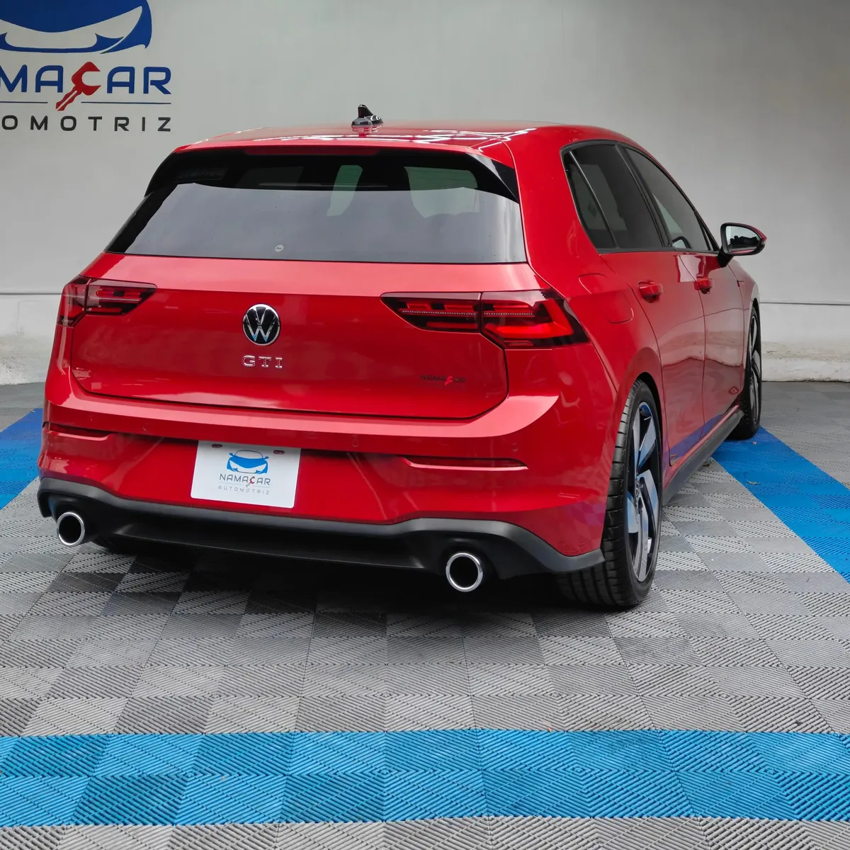 Hatchback deportivo Volkswagen Golf GTI 2.0 L de 241 HP automático DSG7 año 2024 seminuevo en color rojo brillante, vista exterior trasera en ángulo de tres cuartos derecha exhibido en Namacar Automotriz.