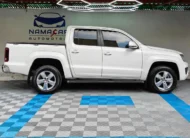 Camioneta pickup Volkswagen Amarok 2.0 Highline 4Motion automática año 2018 seminueva en color blanco, vista exterior de perfil lateral derecho completo exhibida en Namacar Automotriz.