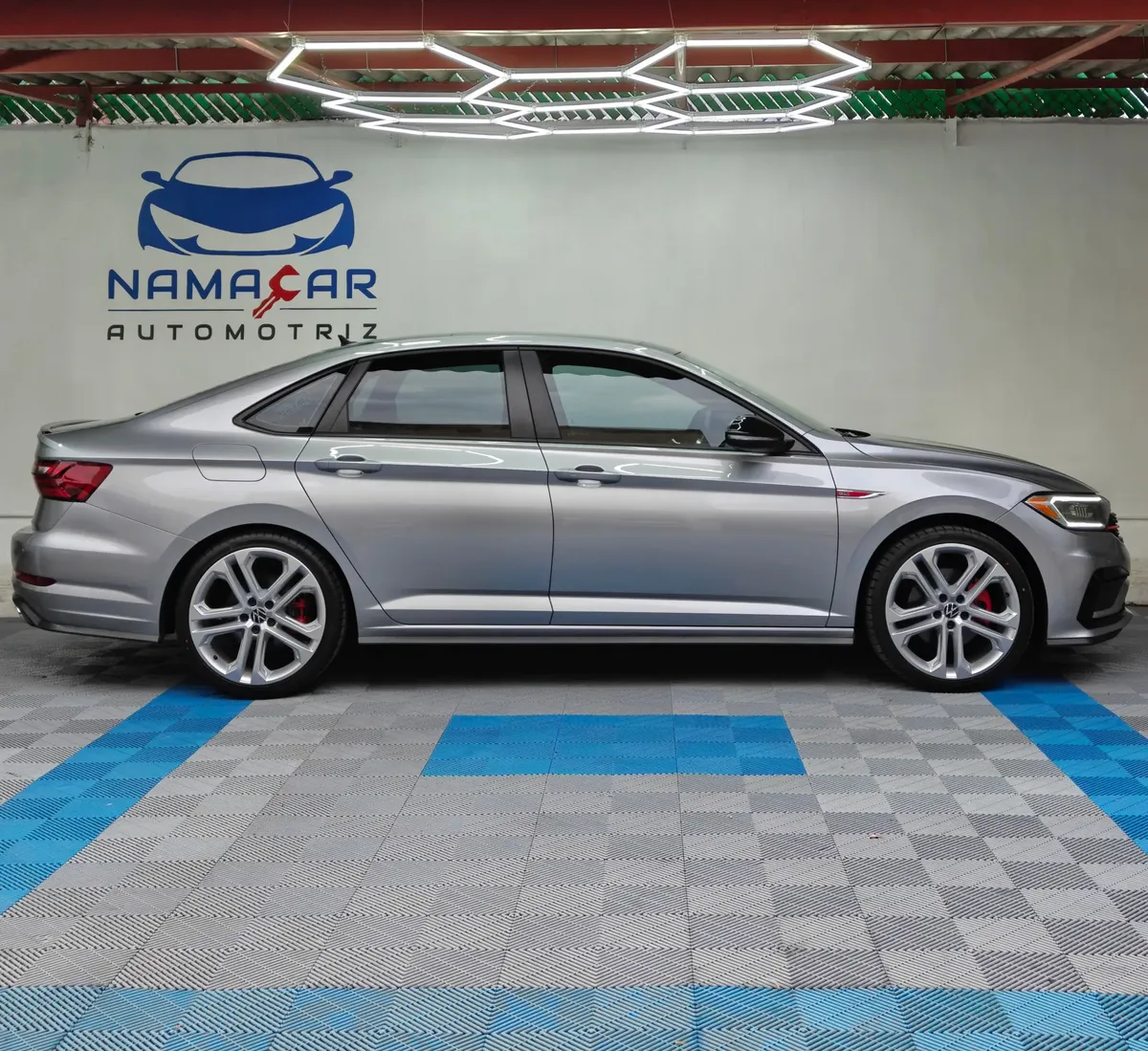 Auto sedán deportivo Volkswagen Jetta 2.0 GLI DSG automático año 2021 seminuevo en color gris plata, vista exterior de perfil lateral derecho completo exhibido en Namacar Automotriz.