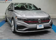 Auto sedán deportivo Volkswagen Jetta 2.0 GLI DSG automático año 2021 seminuevo en color gris plata, vista exterior frontal en ángulo de tres cuartos derecha exhibido en Namacar Automotriz.
