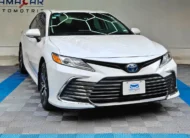 Auto sedán híbrido Toyota Camry 2.5 HEV XLE año 2024 seminuevo en color blanco, vista exterior frontal en ángulo de tres cuartos derecha exhibido en Namacar Automotriz.