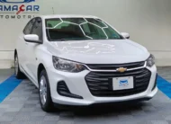 Auto sedán subcompacto Chevrolet Onix 1.3 LS manual año 2024 seminuevo en color blanco, vista exterior frontal en ángulo de tres cuartos derecha exhibido en Namacar Automotriz.