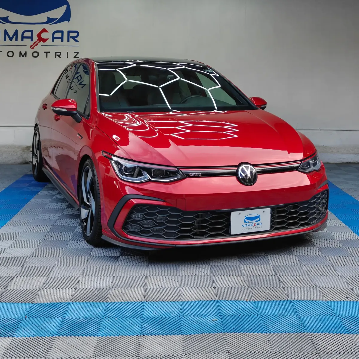 Hatchback deportivo Volkswagen Golf GTI 2.0 L de 241 HP automático DSG7 año 2024 seminuevo en color rojo brillante, vista exterior frontal en ángulo de tres cuartos derecha exhibido en Namacar Automotriz.