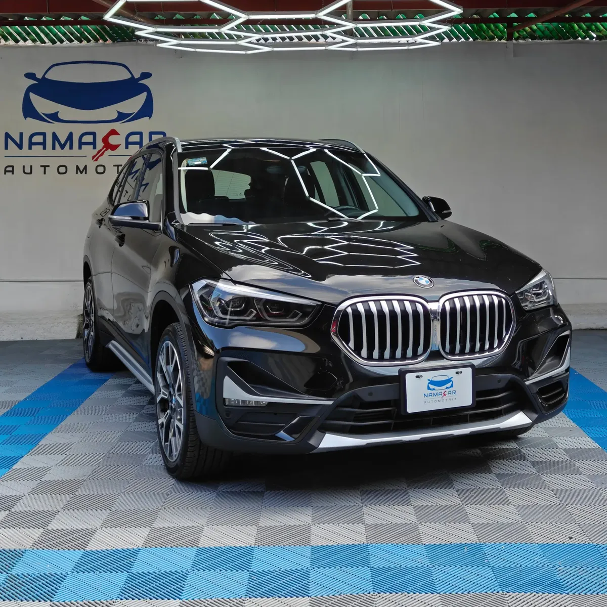 Camioneta SUV de lujo BMW X1 2.0 sDrive20i sDrive 20iA X Line transmisión automática año 2022 seminueva en color negro, vista exterior frontal en ángulo de tres cuartos derecha exhibida en Namacar Automotriz.