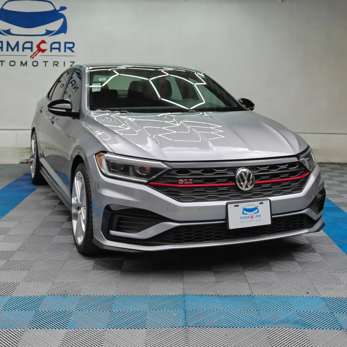 Auto sedán deportivo Volkswagen Jetta 2.0 GLI DSG automático año 2021 seminuevo en color gris plata, vista exterior frontal en ángulo de tres cuartos derecha exhibido en Namacar Automotriz.