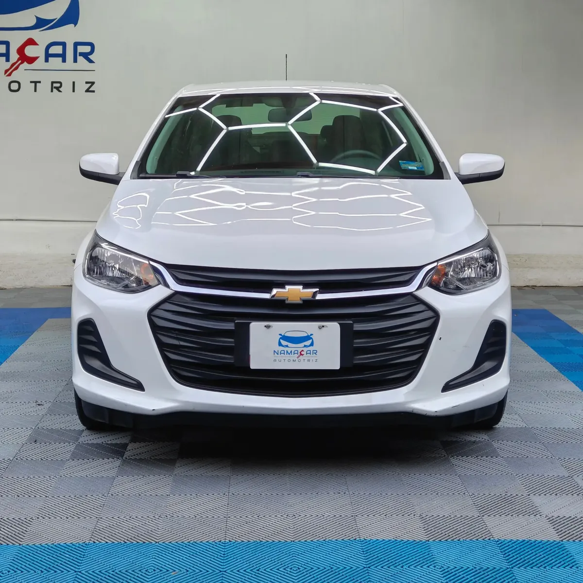 Auto sedán subcompacto Chevrolet Onix 1.3 LS manual año 2024 seminuevo en color blanco, vista exterior frontal directa y centrada exhibido en Namacar Automotriz.